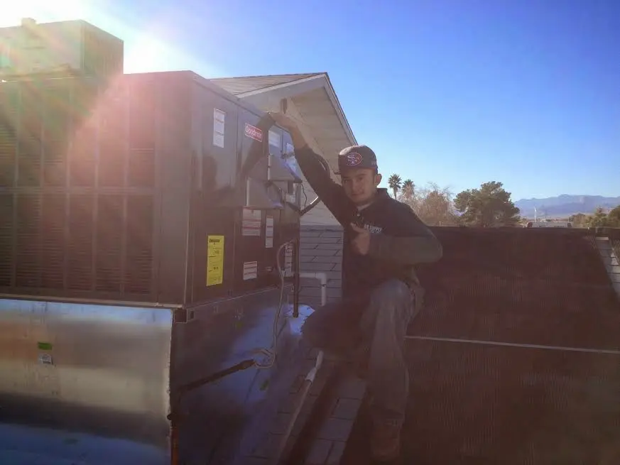 HVAC technician performing Heat Pump Repair on a rooftop unit in Shelbyville